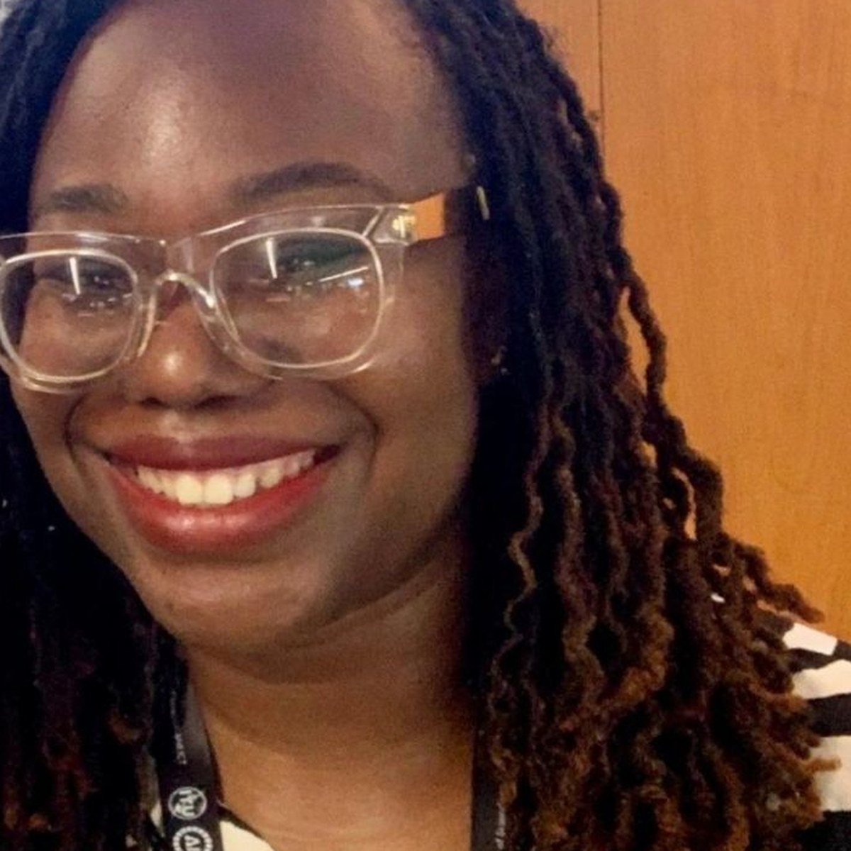Nana Nwachukwu smiling, wearing clear glasses